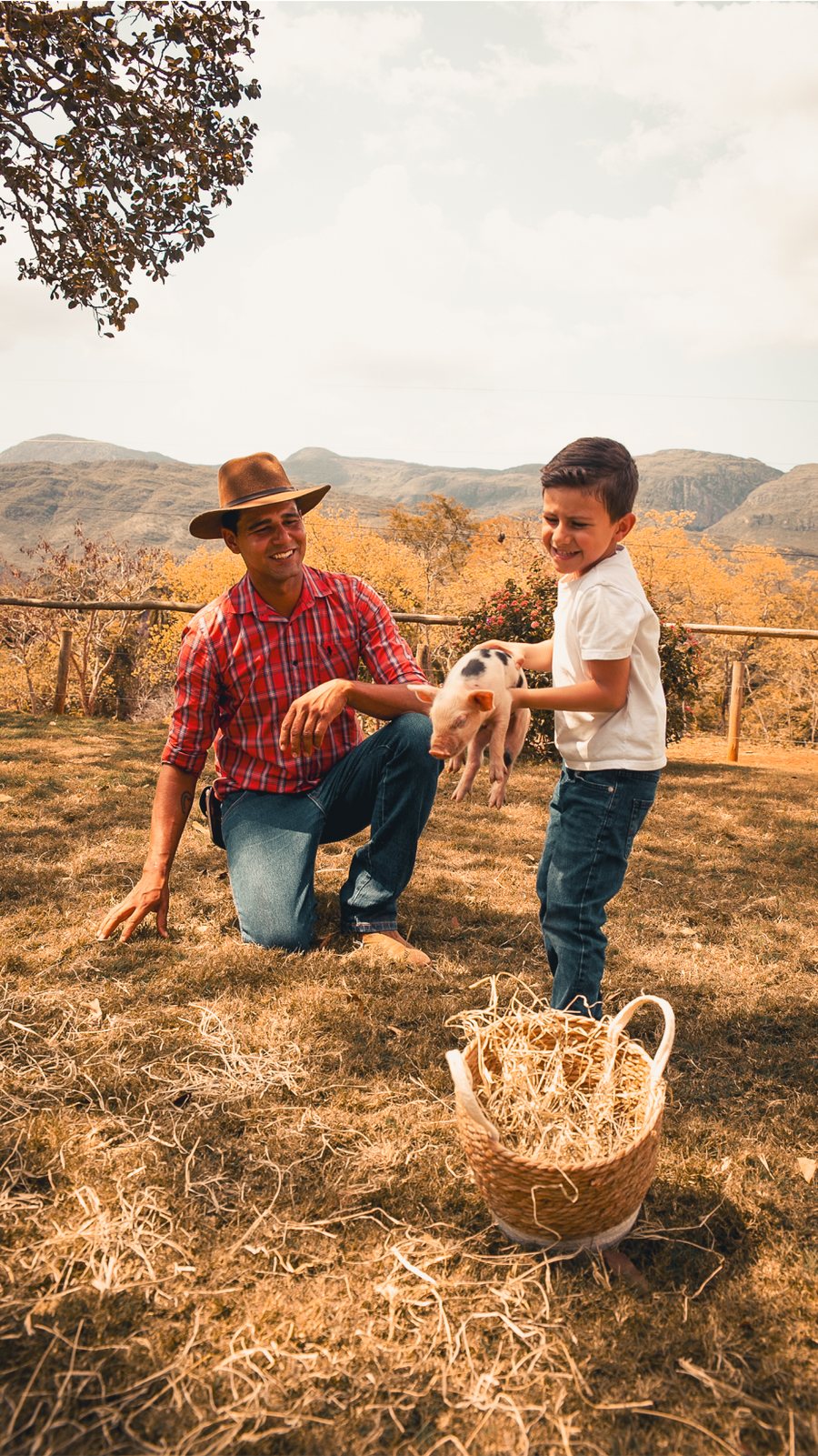 Homem e criança brincando com um bichinho na fazenda